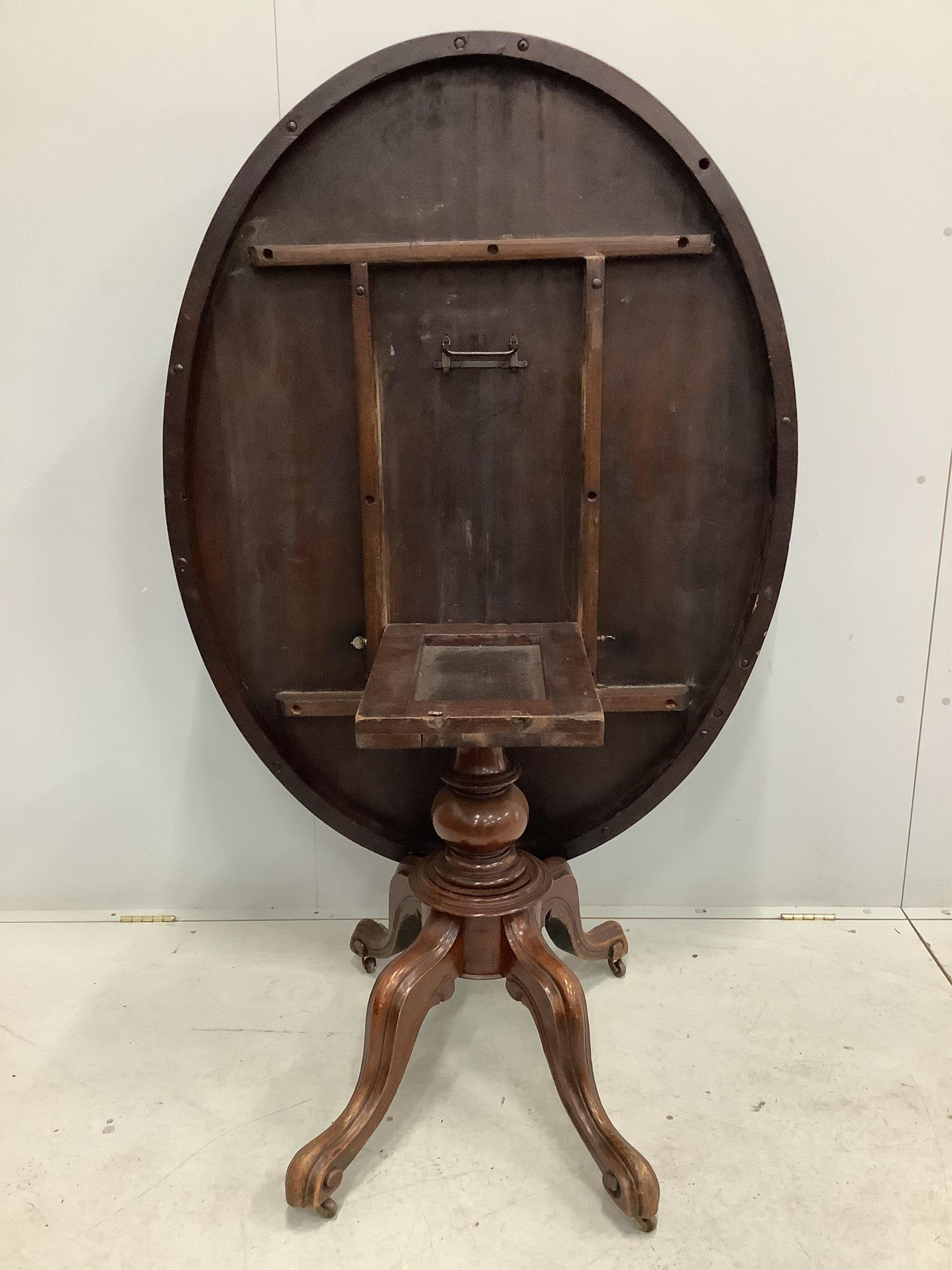 A Victorian mahogany oval tilt top breakfast table, width 135cm, depth 101cm, height 75cm. Condition - poor, some staining to the top